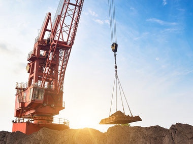 Crane moving rocks in sunset